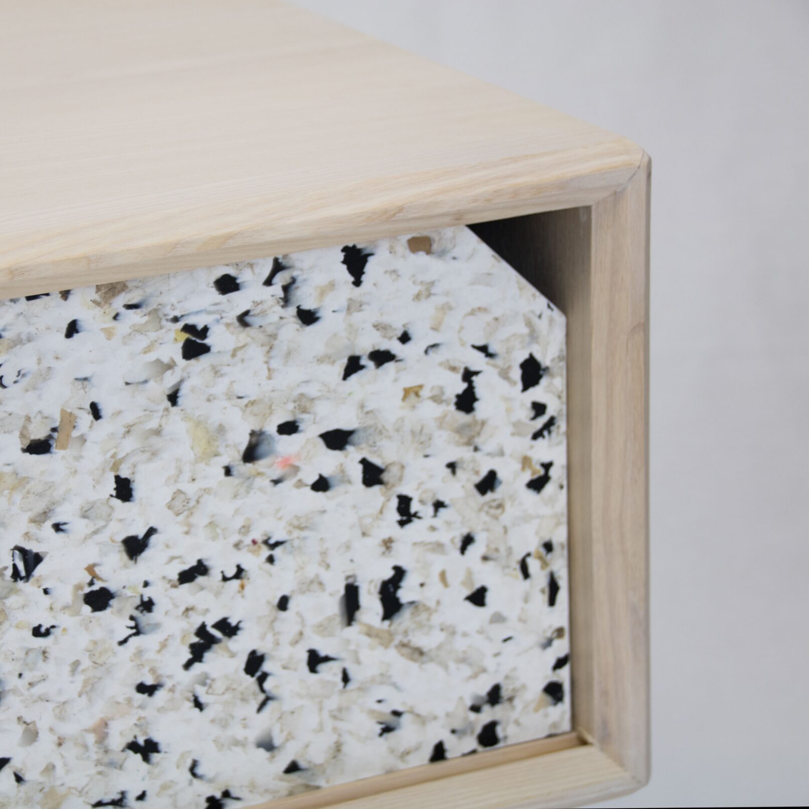 detail view of the confetti sideboard showingthe two material colliding and the opening in the sliding door in recycled plastic